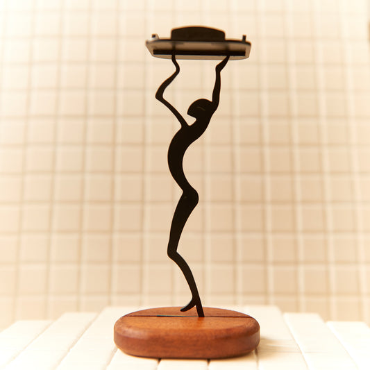 Minimalist black metal alien figurine reaching upward on a mahogany wood base – handmade cosmic-themed candle holder by Zeugman.