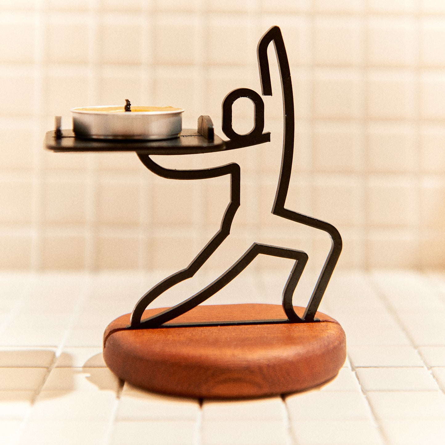 Handcrafted Warrior Pose candle holder made of metal and mahogany, symbolizing strength and focus.