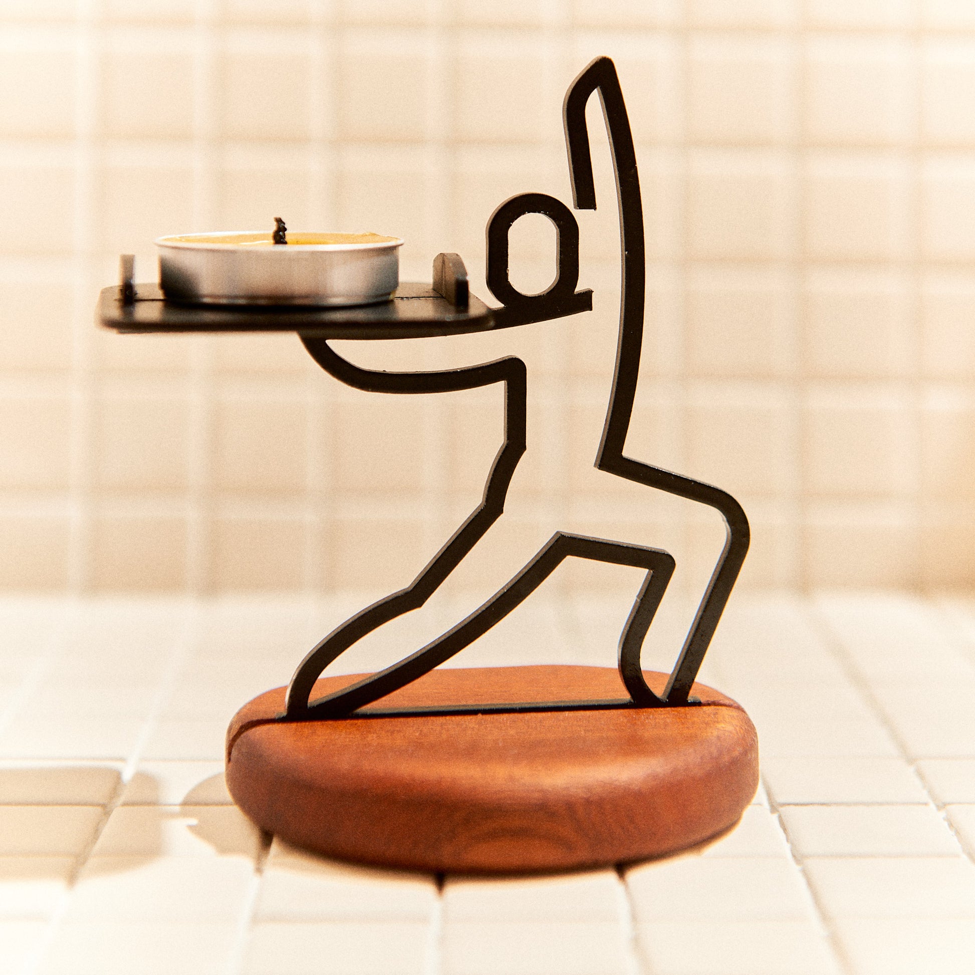 Handcrafted Warrior Pose candle holder made of metal and mahogany, symbolizing strength and focus.