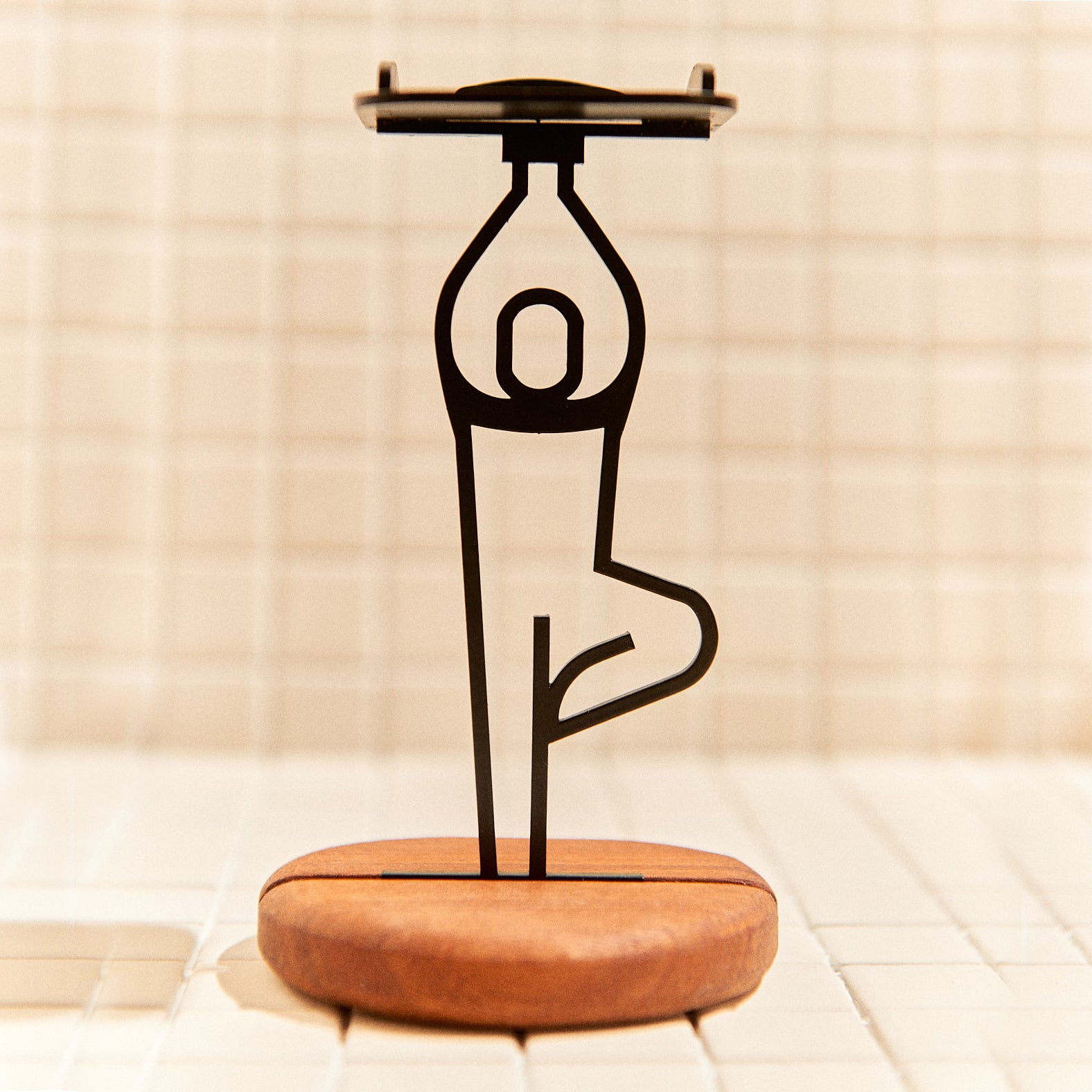 Handcrafted Tree Pose candle holder made of metal and mahogany, symbolizing grounding and balance.
