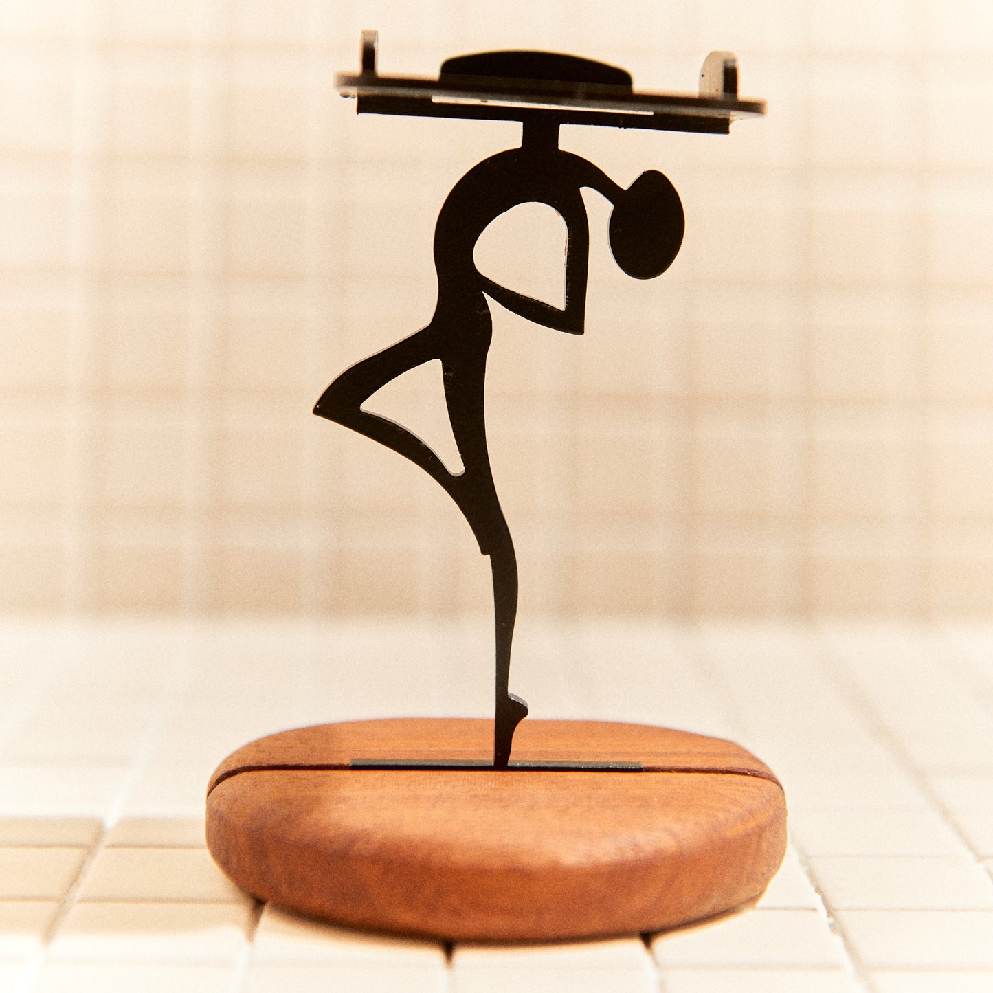 Metal alien figure on mahogany base, modern mystical home accessory.