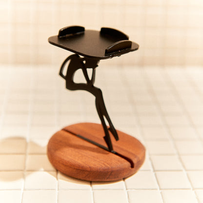 Metal alien figure candle holder on mahogany base, artistic home accent.