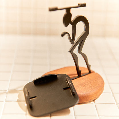 Metal space walker sculpture on mahogany base, cosmic home accent.