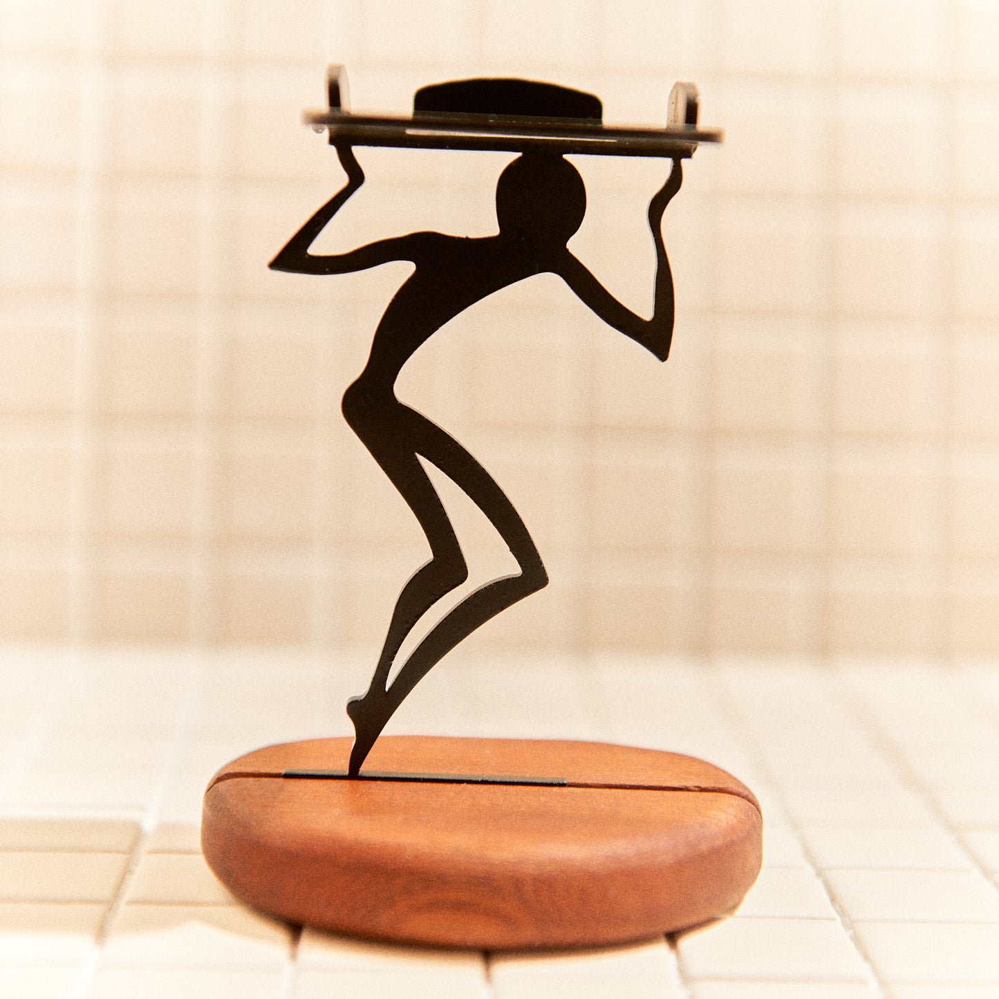 Minimalist alien figure carrying a candle, handcrafted decor inspired by space art.