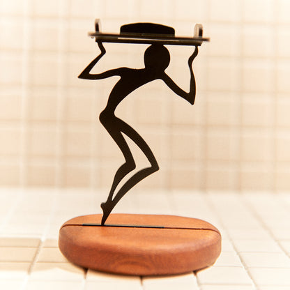 Minimalist alien figure carrying a candle, handcrafted decor inspired by space art.