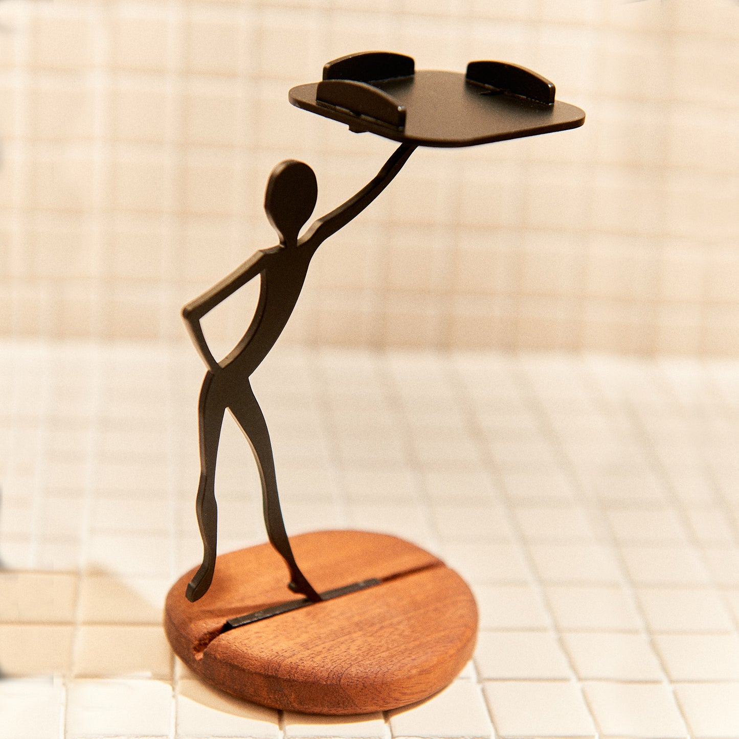 Minimalist alien figure with expressive pose holding a candle platform.