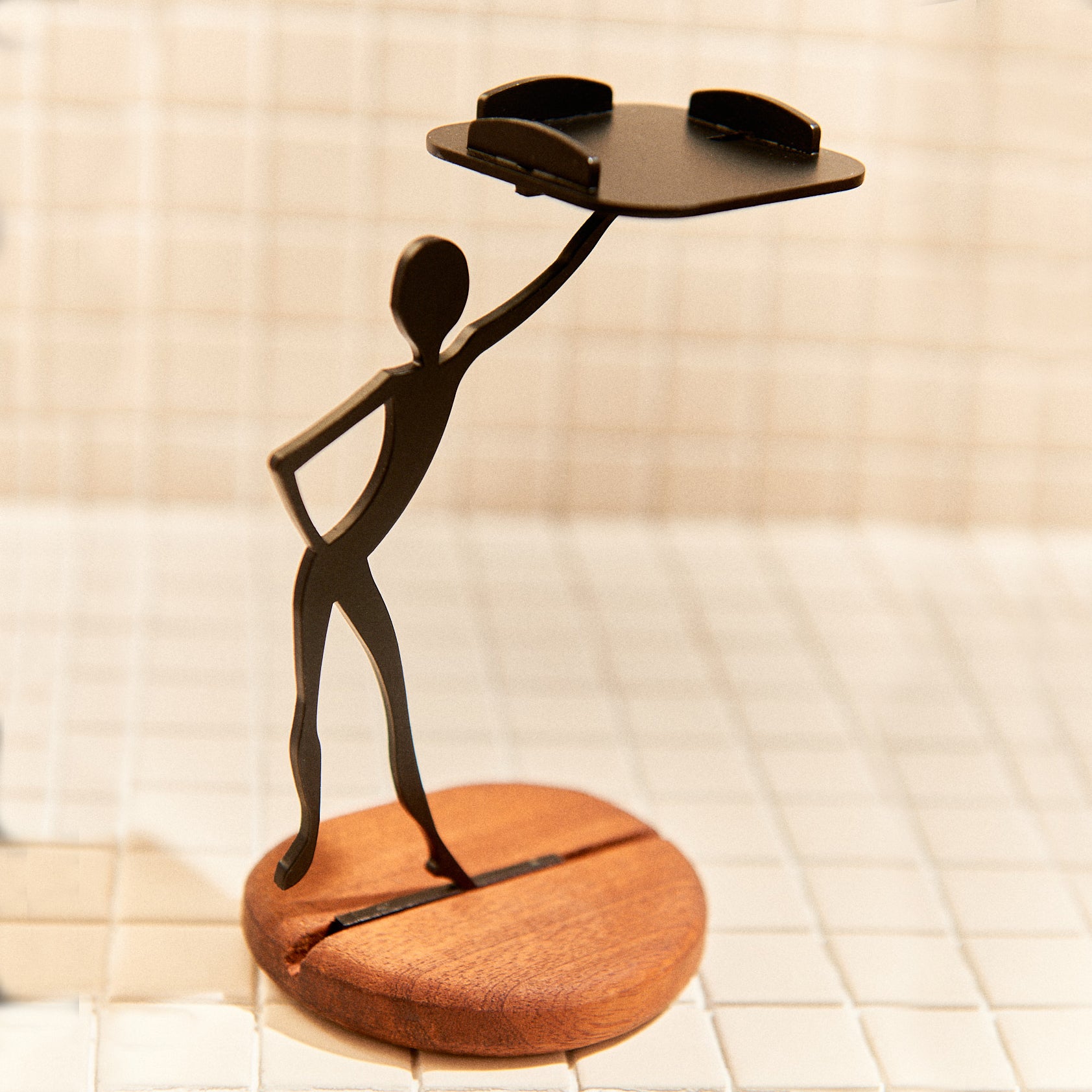 Minimalist alien figure with expressive pose holding a candle platform.