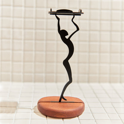 Close-up of alien-shaped metal candle holder holding a tealight, on polished mahogany base – modern sci-fi home decor.