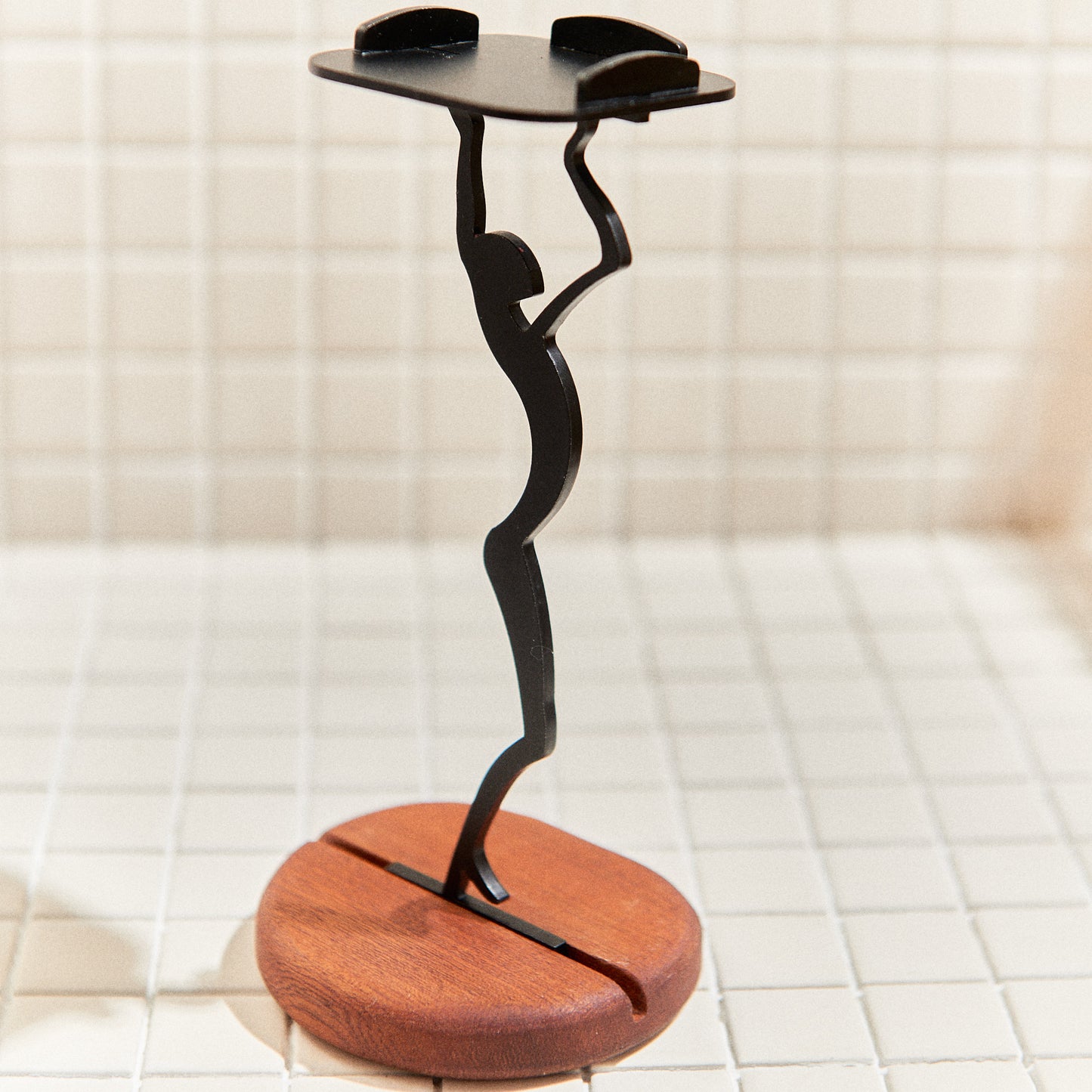 Side view of sleek alien figurine candle holder stretching upward – minimalist extraterrestrial art sculpture on wood base.