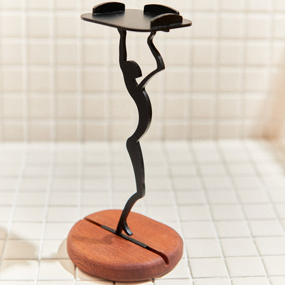 Side view of sleek alien figurine candle holder stretching upward – minimalist extraterrestrial art sculpture on wood base.